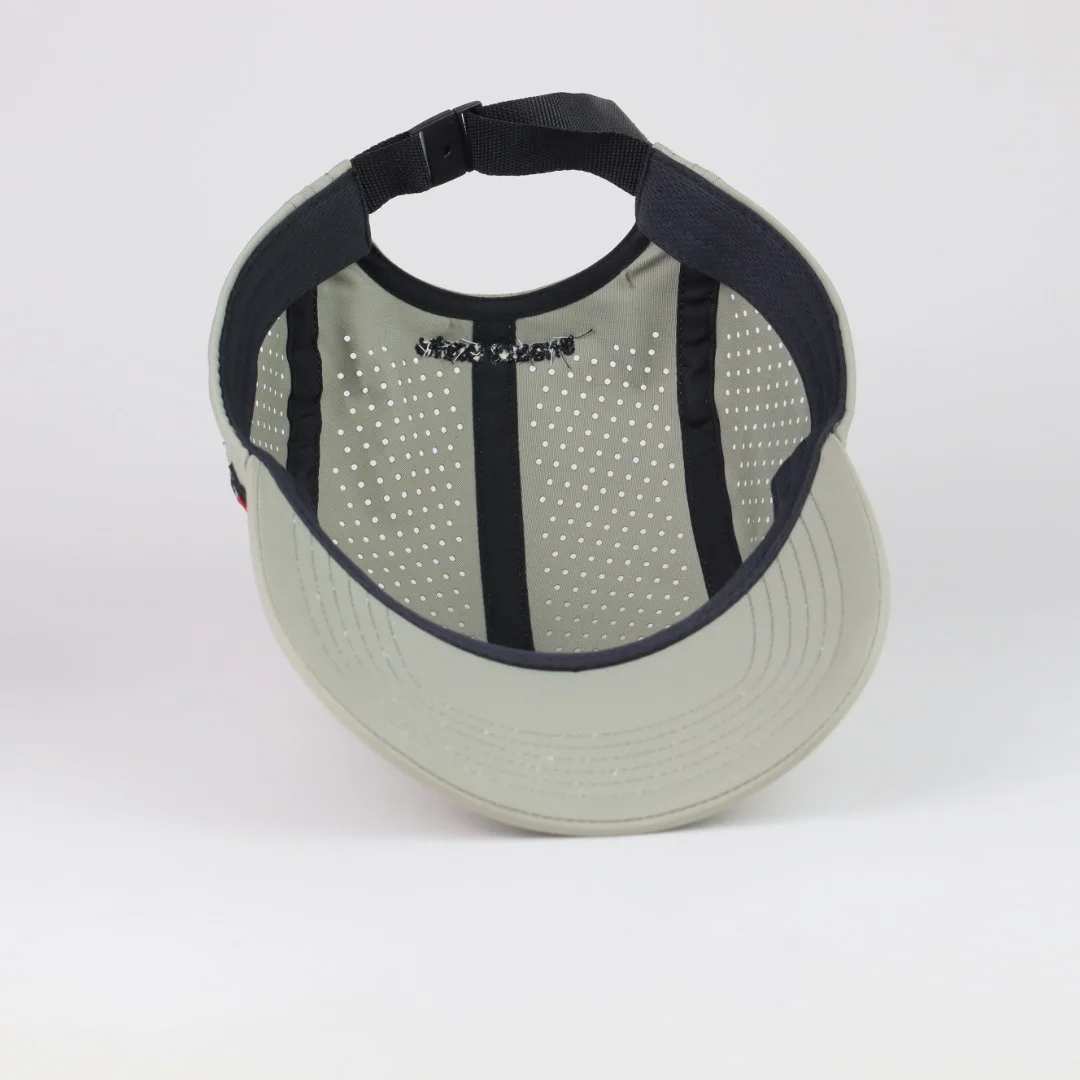 Inside of a perforated performance cap showing panel seams, internal finishing and an adjustable black webbing strap