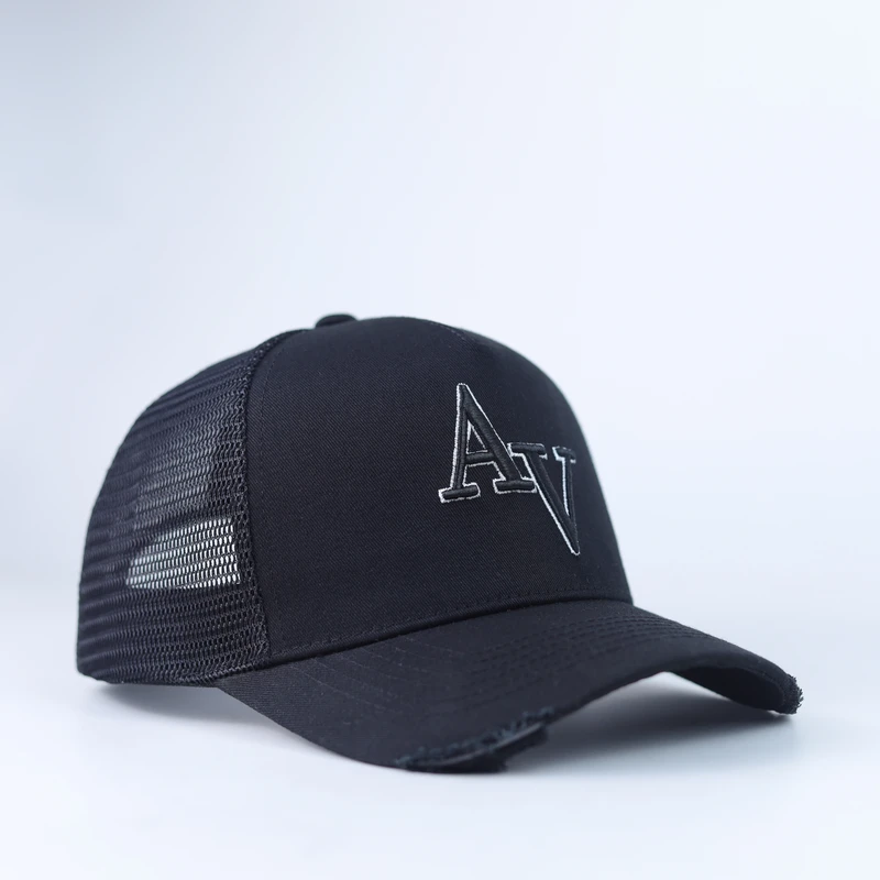 Black mesh trucker cap seen from the front side with outlined white letter embroidery