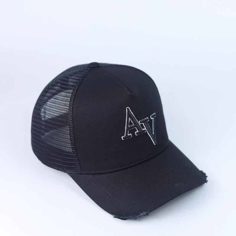 Angled view of black mesh trucker with outlined lettering and slightly distressed curved visor