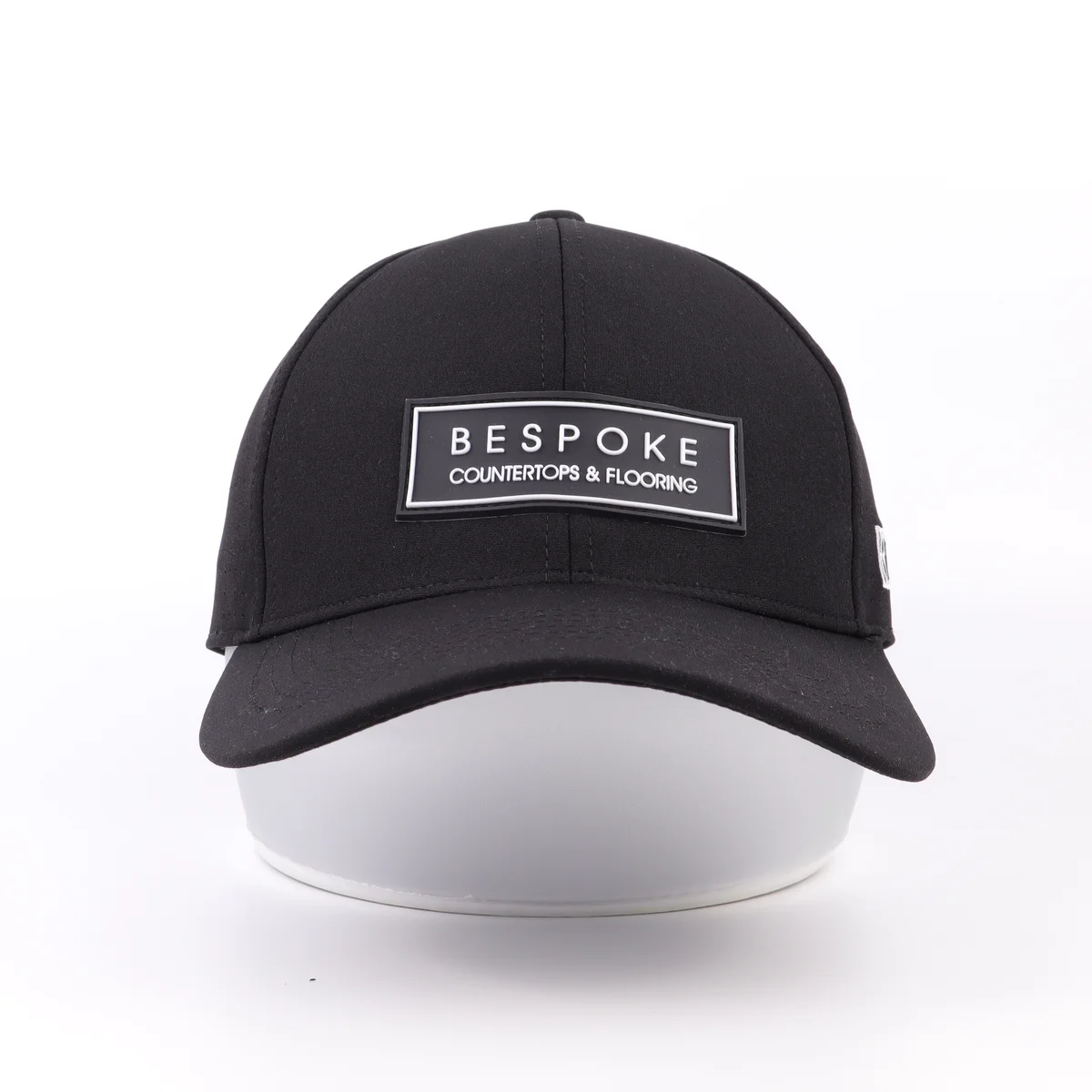 Front of a black perforated cap with rectangular patch above the curved visor