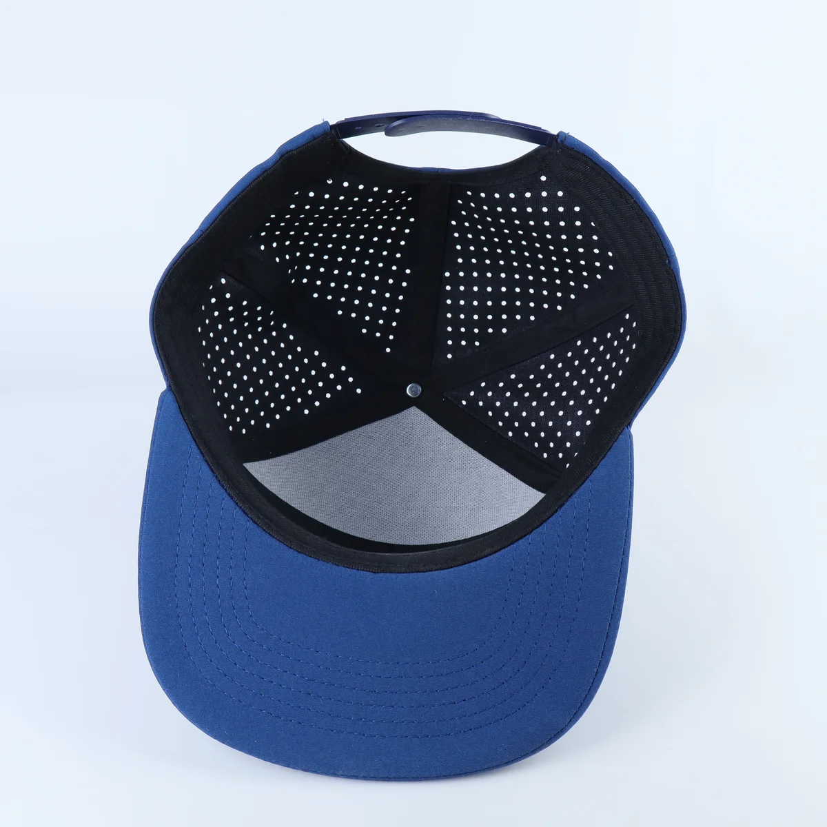 Interior of a blue cap showing perforated crown panels and dark seam tape